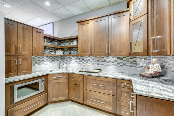 Kitchen showroom with wooden cabinetry and marble countertops